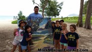 Mark N. Brown and young Punahou School students proudly show off his donated artwork